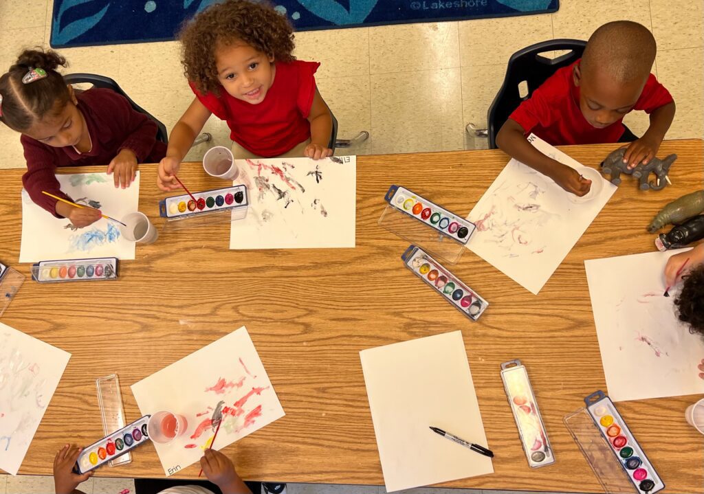 Kids painting with paints on the white paper